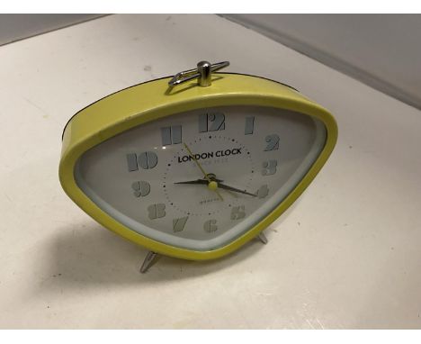 A RETRO LOOKING YELLOW ALARM CLOCK 