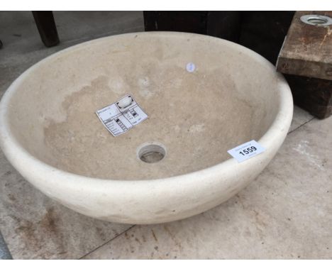 A CREAM WASH BASIN FORMED FROM A SOLID PIECE OF MARBLE 
