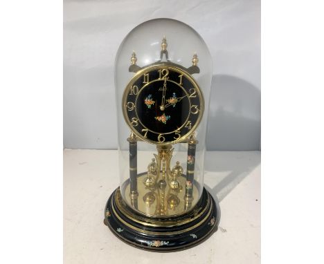 AN ANNIVERSARY CLOCK WITH GLASS DOME AND FLORAL DECORATION 