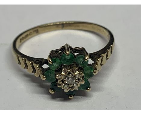 A 9 CARAT GOLD RING WITH A CENTRAL DIAMOND AND EIGHT SURROUNDING EMERALDS IN A FLOWER DESIGNSIZE K IN A PRESENTATION BOX 
