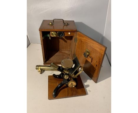 A VINTAGE BRASS AND CAST MICROSCOPE WITH THREE LENSES IN A MAHOGANY BOX WITH BRASS FITTINGS. AN INNER DRAWER CONTAINS PRESENT