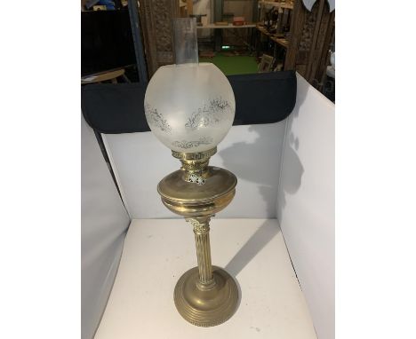 A BRASS OIL LAMP WITH A GLASS FUNNEL AND SHADE 
