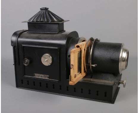 A Houghton-Butcher magic lantern projector converted to electric with storage tin and assorted spare parts.  