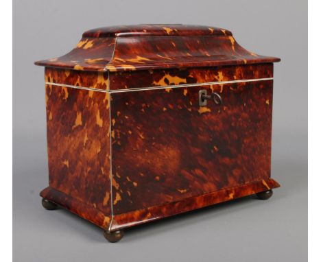 A 19th century tortoise shell tea caddy raised on four bun feet. Having silvered banding and monogrammed to cover. With key. 