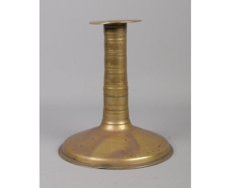 A 17th century brass candlestick with trumpet base and bobbin stem. Height 19.5cm.  