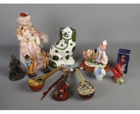 A collection of figures including a ceramic dog and wooden miniature instruments.  