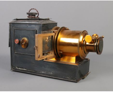 A magic lantern projector stamped The Valor Co. Birmingham converted to electric with storage tin.  