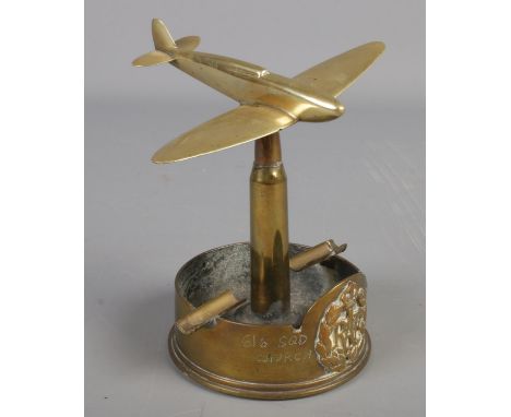 A RAF brass trench art ashtray. Formed as a war plane at the top of a bullet. Baring broad arrow mark to the base.  