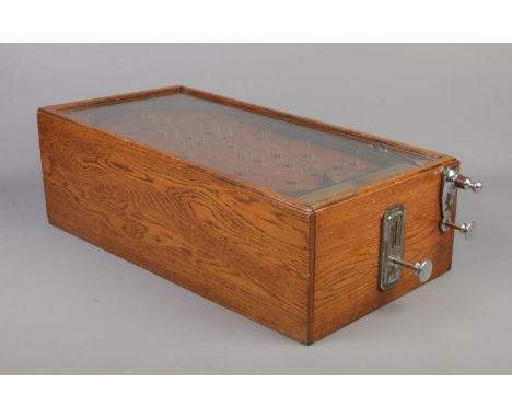 An early 20th century bagatelle game, The Advance Pin Table. With oak case and glazed top, being coin operated. Height 19cm, 