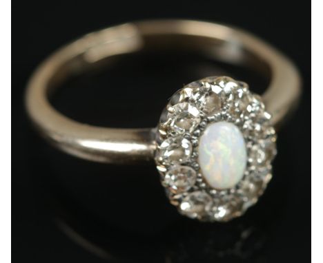 An 18ct gold opal and diamond ring. Central opal surrounded by ten diamonds. Size N, 3.68g.  