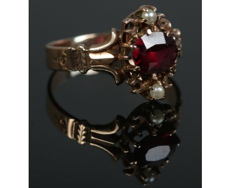 A nineteenth century ring set with central garnet and pearls. Tests to 9ct Gold. Size K. Total weight: 1.9g  