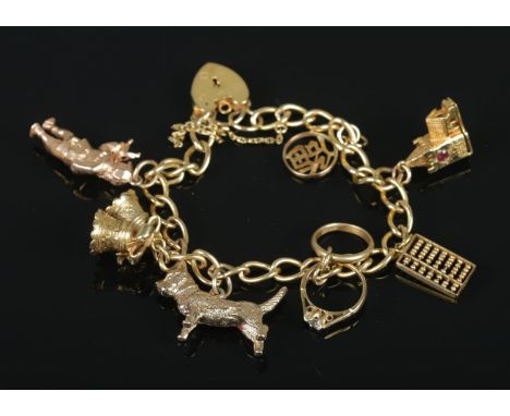 A 9ct gold charm bracelet with 9ct gold and 14ct gold charms. 32.07g.  14ct gold charms include abacus and Chinese symbol. 9c