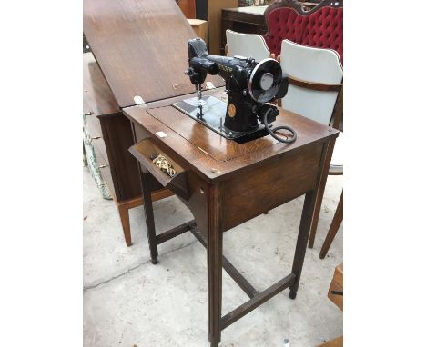 A VINTAGE OAK SEWING TABLE MACHINE WITH SINGER SEWING MACHINE 