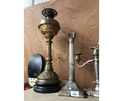 A BRASS OIL LAMP AND SILVER PLATED CORINTHIAN COLUMN CANDLE STICK (2) 