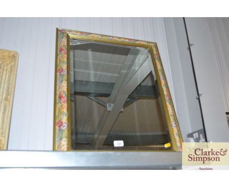 A modern bevel edged and flower patterned framed mirror