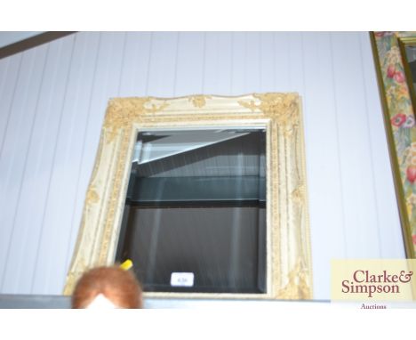 A small mirror with decorative cream painted frame