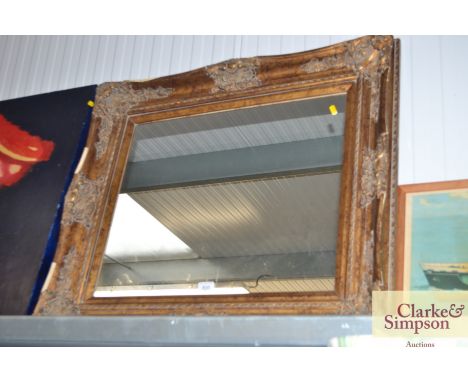 A wall mirror contained in gilt ornate frame