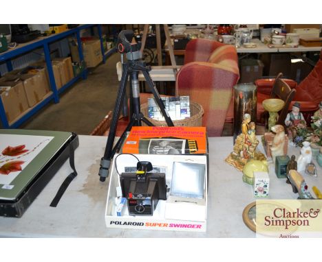 A camera tripod together with a wicker basket and a Polaroid camera with original box