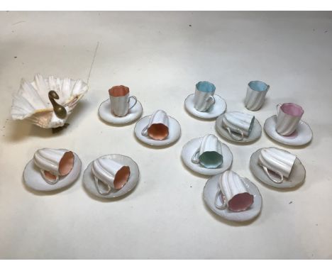 A Swedish set of 10 porcelain fluted cups and saucers, decorated with different coloured interiors, together with a conch she