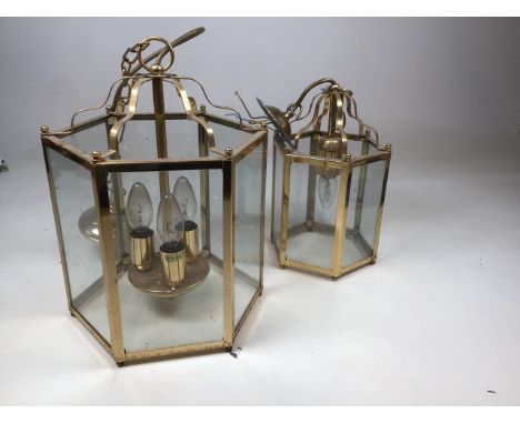 A large hexagonal brass hall lantern with glass panels in the traditional style, and a smaller lantern of matching taste. H:4