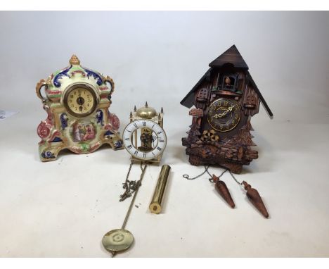 Three clocks to include a modern resin cuckoo clock, a continental clock in ceramic case, and one other 