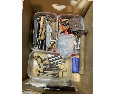 A plastic toolbox containing random hand tools along with some rubber straps and also another box containing random hand tool