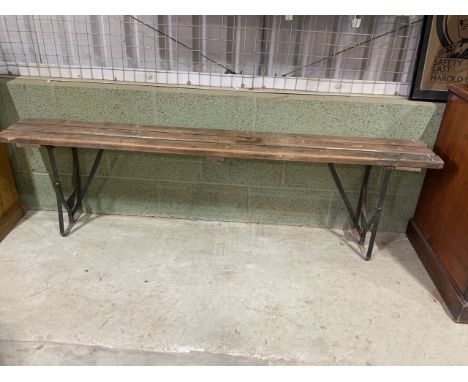 A wooden slatted folding bench with metal legs and suppports. W:180cm x D:24cm x H:52cm