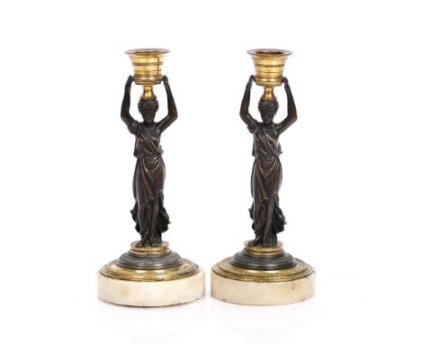 A pair of Regency bronze candlesticks each on a circular marble base, 20cm high