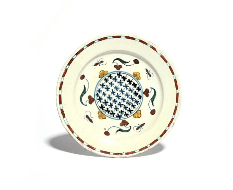 A rare Vauxhall delftware plate  c.1720, painted to the well with a circular trellis panel surrounded by stylized flower spri