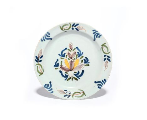 A delftware plate  c.1740-50, simply decorated in green, blue, yellow, red and manganese with a stylized flower spray to the 