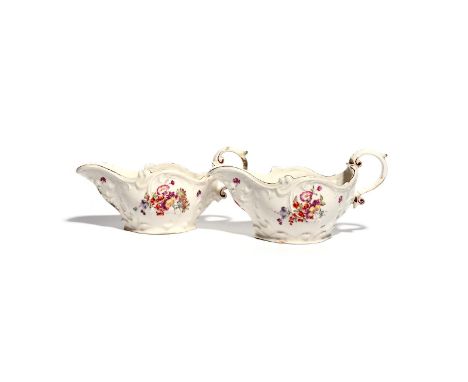 A large pair of Longton Hall sauceboats  c.1755, the generous scroll-moulded forms painted with sprays of flowers including r