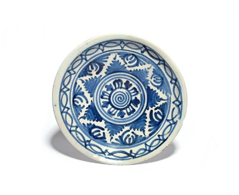 A delftware charger  c.1700, probably London, decorated in underglaze blue with a geometric leaf design around a central swir