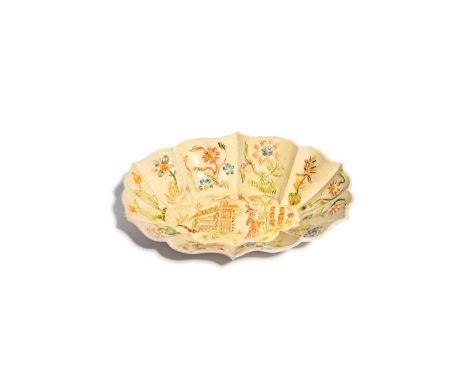 A Staffordshire salt-glazed small dish or tray  c.1750, moulded with a Chinese figure standing before a pagoda, the shaped ri