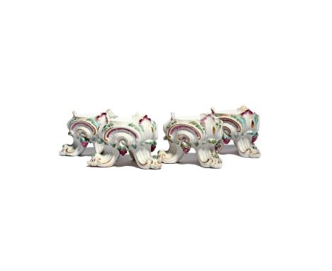 Four Chelsea tripod stands c.1760, a bunch of grapes hung between each scrolling foot, the top of which terminates in a shell
