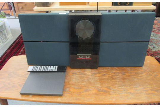 A Bang & Olufsen BeoSound Century CD and cassette player with integral speakers and a remote cont