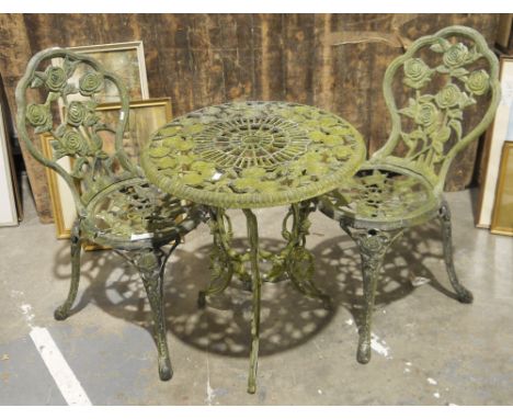 Weathered aluminium garden tripod table and two chairs, cast with interlocking roses, the table 67cm high and the chairs 86cm