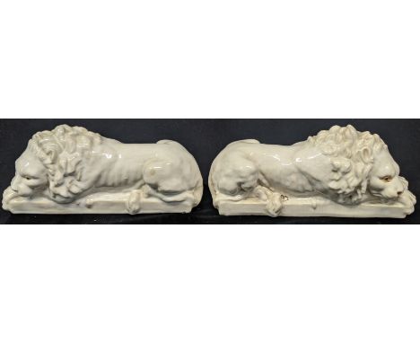 A pair of early 20th century white ceramic lions, H.14cm L.33cm