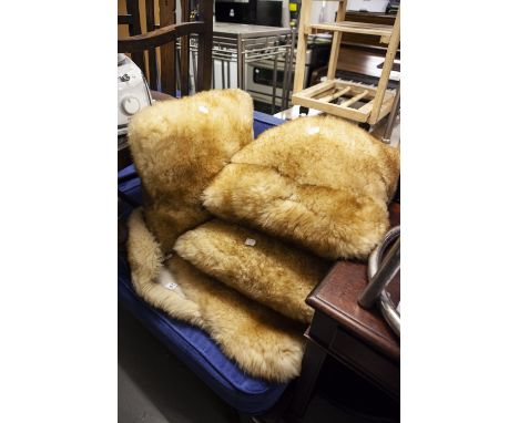 A NATURAL GREY SHEEPSKIN RUG AND A LIGHT BROWN SHEEPSKIN RUG, AND THREE FUR FABRIC CUSHIONS 