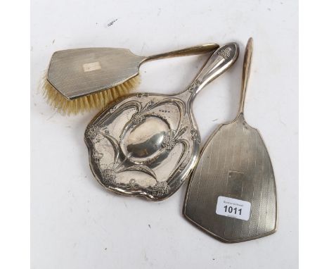 An engine turned silver-backed dressing table mirror and matching brush, and an Art Nouveau silver-backed dressing table mirr