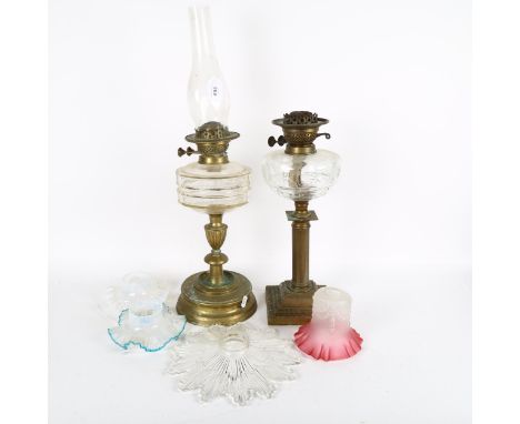 A brass oil lamp with glass font and chimney, 63cm, another, and 4 decorative Vintage glass lampshades 