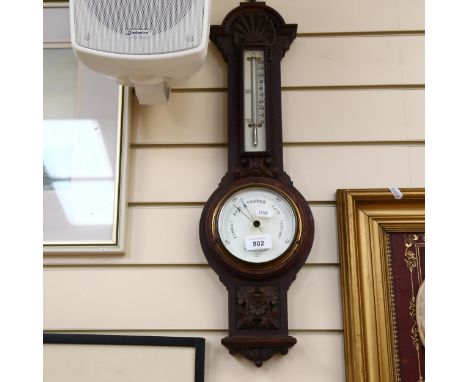 A barometer and thermometer in carved oak, by Negretti & Zambra, 61cm 