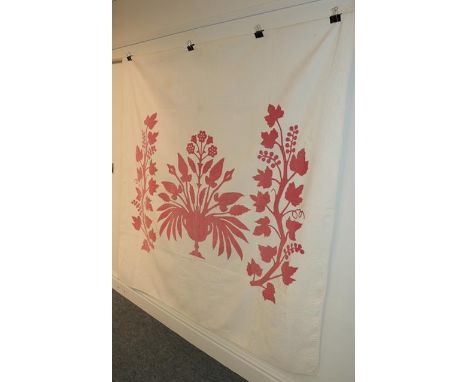 19th century white quilt with large red cotton appliquéd image of a central pedestal vase of flowers, flanked by two vines wi