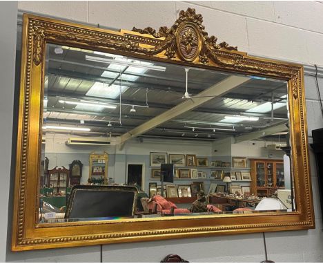 A reproduction gilt framed bevel glass over-mantel mirror, 145cm by 104cm