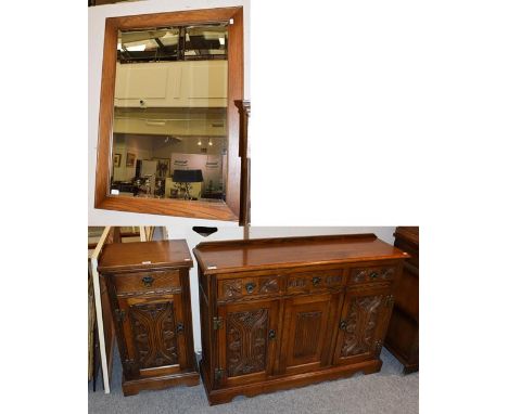 A Wood Brothers reproduction oak sideboard, the moulded top above three drawers with two carved doors and a central linen fol