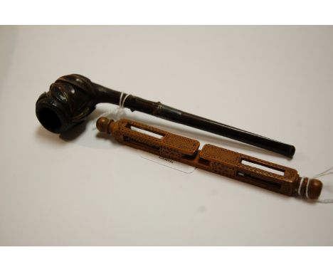 An early 20th century pipe, the bowl carved with leaves; together with a carved wooden wool-winder (2)
