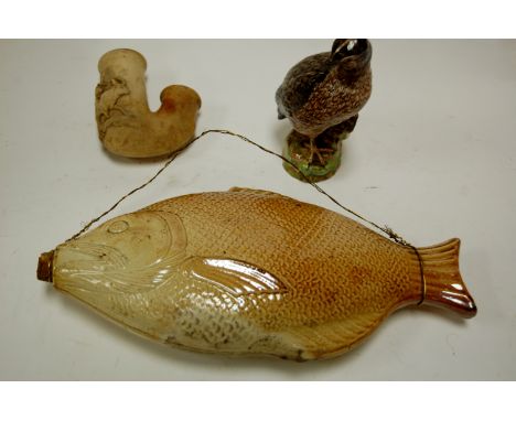 A Victorian stoneware decanter in the form of a fish; together with a ceramic pipe; and a continental figure of a bird (3) Co