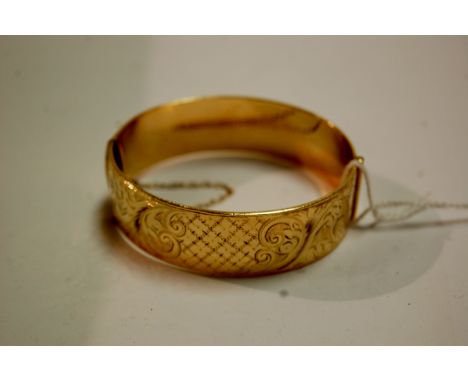 A 9ct gold plated hinged bangle with engraved decoration and safety chain (boxed)