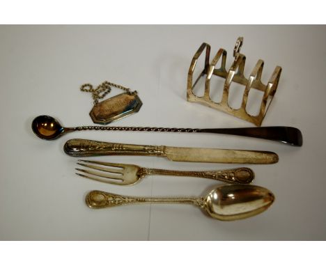 An early 20th century silver four division toast rack together with a loose silver plated iced tea spoon, silver Irish whisky