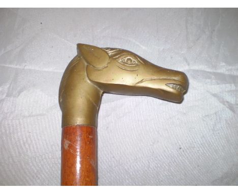 A TWO PIECE WOODEN WALKING STICK WITH BRASS HORSE HEAD GRIP