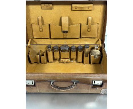 A Finnigan's of New Bond Street London Edwardian brown hide weekend case with rain cover complete with a collection of six cr